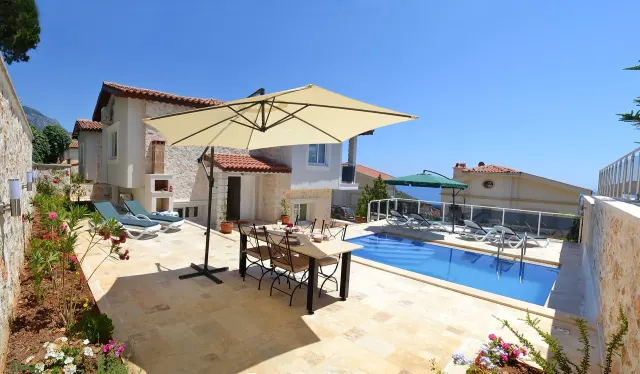 BookNoFees: بيت عطلات في Kalkan, Kas, Antalya – شرفة مع طاولة طعام ومظلة ومسبح وكراسي استلقاء